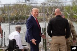 Kandidat presiden dari Partai Republik, mantan Presiden Donald Trump, memberi isyarat setelah melambai kepada orang-orang di seberang Rio Grande di Meksiko di Shelby Park saat berkunjung ke perbatasan AS-Meksiko, Kamis, 29 Februari 2024, di Eagle Pass, Texas. (Foto: AP/Eric Gay)