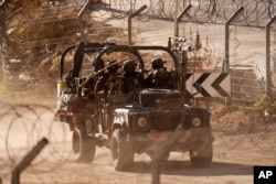Israeli soldiers drive an armored vehicle along the security fence near the so-called Alpha Line that separates the Israeli-controlled Golan Heights from Syria, in the town of Majdal Shams, Dec. 19, 2024.