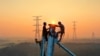 Employees work on a high voltage transmission tower in Yichun, in China's central Jiangxi province, Sept. 28, 2021.