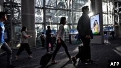 戴着口罩的旅客抵达泰国曼谷的素万那普国际机场。（2020年1月24日）