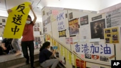 在台湾的香港学生为执行当地政府的指令从一面连侬墙上移走标语。（2019年8月31日）