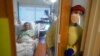 FILE - Registered nurse Rachel Chamberlin steps out of an isolation room where Fred Rutherford recovers from COVID-19 at Dartmouth-Hitchcock Medical Center, in Lebanon, N.H., Jan. 3, 2022.