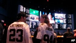 FILE - Football fans wait for kickoff in the sports betting lounge at the Ocean Casino Resort in Atlantic City, N.J., Sept. 9, 2018. When the NFL season kicks off this week, Kentucky residents and visitors — for the first time — will be able to legally place sports bets on something other than horse racing,