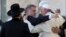 FILE - Pope Francis embraces two good friends traveling with him, Argentine Rabbi Abraham Skorka, center, and Omar Abboud, leader of Argentina's Muslim community, partially seen next to the Pope, after praying at the Western Wall in Jerusalem's Old City, Israel, May 26, 2014.
