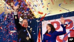 Kandidat Demokrat untuk Senator AS Doug Jones dan istrinya Louise melambai ke pendukung sebelum berbicara pada hari Selasa, 12 Desember 2017 di Birmingham, Alabama.