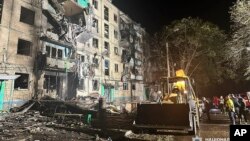 Ljudi se okupljaju ispred zgrade oštećene u ruskom napadu na stambenu zgradu u Harkovu, Ukrajina, 2. oktobra 2024.