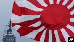 FILE - In this Oct. 14, 2012, photo, Japan Maritime Self-Defense Force escort ship Kurama, left, navigates behind destroyer Yudachi, with a rising sun flag, during a fleet review in water off Sagami Bay, south of Tokyo. 