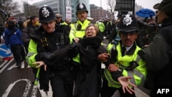 Police officers take away a protester attempting to block the road during a gathering at the site of the former Royal Mint in London to demonstrate against a proposal to move China's embassy to the site in the shadow of the Tower of London, Feb. 8, 2025.