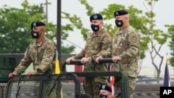 FILE - Incoming commander, Gen. Paul J. LaCamera, right, and outgoing commander, Gen. Robert B. Abrams, center, inspect the troops during a change-of-command ceremony in Pyeongtaek, South Korea, July 2, 2021.