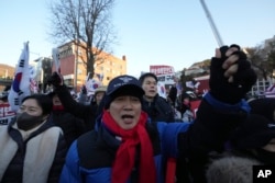 Supporters of impeached South Korean President Yoon Suk Yeol rally against a court's issuance of a warrant to detain Yoon, as police stand guard near the presidential residence in Seoul, South Korea, Jan. 3, 2025.