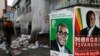 Election campaign posters are pictured near Zimbabweans walking on a street blocked by uncollected garbage in Harare July 17, 2013. President Robert Mugabe&#39;s rivals said the chaotic organisation of early voting for soldiers and police showed Zimbabwe was not ready for the July 31 general election in which nearly six million people had registered to vote.