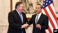 Chinese State Councilor and Foreign Minister Wang Yi, right, talks with U.S. Secretary of State Mike Pompeo, left, before a meeting at the Diaoyutai State Guesthouse in Beijing, Oct. 8, 2018. 