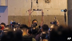 资料照：前香港民主派立法会议员林卓廷（中）在纪念元朗地铁袭击事件一周年的新闻发布会上被防暴警察包围，他用五个手指表达“五项诉求，一个都不能少”的抗议诉求。 （2020年7月21日）