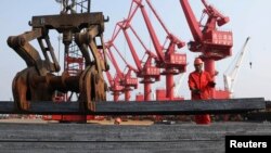 工人在江苏连云港把钢材装船出口