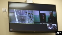 A screen shows jailed Kremlin critic Alexei Navalny as he arrives to listen to an appeal hearing against a court decision to jail him for 19 years in a maximum security prison on extremism-linked charges, at a court in Moscow on Sept. 26, 2023.