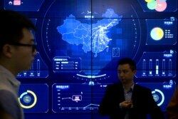 In this April 26, 2018, photo, visitors stand in front of an electronic data display showing a map of China at the Global Mobile Internet conference in Beijing. A California-based security-research firm said Wednesday, July 11, 2018, that it found evidence that an elite Chinese government-linked hacking team has penetrated computer systems belonging to Cambodia's election commission, opposition leaders and media in the months leading up to Cambodia's July 29 election. (AP Photo/Mark Schiefelbein)