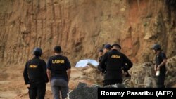 Polisi bersiap meledakkan bahan peledak di Sibolga, Sumatra Utara, pada 14 Maret 2019. Bahan peledak tersbeut ditemukan dari tersangka dalam tahanan polisi yang diidentifikasi sebagai anggota Jemaah Ansharut Daulah (JAD). (Foto: AFP/Rommy Pasaribu)