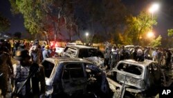 Sejumlah anggota kepolisian memeriksa lokasi ledakan di luar bandara Karachi, Pakistan, pada 7 Oktober 2024. (Foto: AP/Fareed Khan)