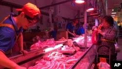 资料照:一名北京市民在一家肉铺购买猪肉。(2019年9月11日)