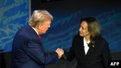 2024年9月10日，美国副总统兼民主党总统候选人卡玛拉·哈里斯(Kamala Harris)(右)在宾夕法尼亚州费城国家宪法中心举行的总统辩论中与美国前总统、共和党总统候选人唐纳德·特朗普(Donald Trump)握手。（索尔·勒布/法新社拍摄）