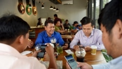 រូបឯកសារ៖ បុរសមួយក្រុមកំពុងប្រើប្រព័ន្ធអ៊ីនធឺណិតតាមទូរស័ព្ទទំនើបរបស់ពួកគេ នៅក្នុងហាងកាហ្វេមួយ នៅរាជធានីភ្នំពេញ កាលពីថ្ងៃទី១៧ ខែតុលា ឆ្នាំ២០១៨។