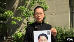 遭中国拘禁台湾人权工作者李明哲之妻李净瑜抱着李明哲像 (2017年5月17日，美国之音钟辰芳拍摄)