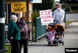 Orang-orang melambaikan plakat menentang kejahatan rasial anti-Asia yang diadakan oleh Asian American Pacific Islanders (AAPI) Organizing Coalition Against Hate and Bias di Newcastle, Washington, AS, 17 Maret 2021. (Foto: REUTERS)