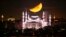 Bulan sabit tampak menjelang terbenam di belakang kubah Masjid Sultanahmet yang dikenal sebagai &quot;Masjid Biru&quot; selama bulan suci Islam Ramadan di Istanbul, Turki. (AP)&nbsp;