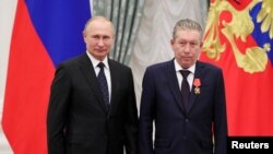 Presiden Rusia Vladimir Putin bersama VP perusahaan minyak "Lukoil", Ravil Maganov, dalam sebuah acara pemberian penghargaan di Kremlin pada 21 November 2019 (foto: dok). 