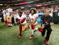 FILE - San Francisco 49ers quarterback Colin Kaepernick (7) and outside linebacker Eli Harold (58) kneel during the playing of the national anthem before an NFL football game against the Atlanta Falcons in Atlanta.