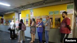 Orang-orang mengantre untuk memberikan suara mereka di luar tempat pemungutan suara selama pemilihan presiden, di Porto Alegre, Brazil, 30 Oktober 2022. REUTERS/Diego Vara