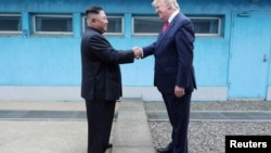 Presiden AS Donald Trump berjabat tangan dengan pemimpin Korea Utara Kim Jong Un saat mereka bertemu di zona demiliterisasi. (Foto: Reuters)