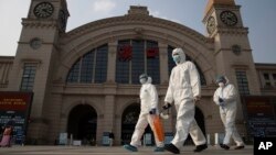 Petugas mengenakan APD berjalan melewati stasiun kereta Hankou di Wuhan, provinsi Hubei China tengah, 7 April 2020. (Foto: dok). Tim pakar WHO akan tiba di Wuhan pekan ini untuk memulai investigasi terkait asal usul pandemi Covid-19.