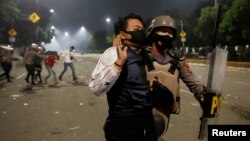 Seorang polisi menahan seorang demonstran dalam unjuk rasa menentang UU Cipta Karya di Jakarta, 8 Oktober 2020. (Foto: Reuters)