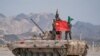 Tentara China dari Tentara Pembebasan Rakyat (PLA) berpose untuk foto dengan bendera nasional China di sebuah tank di Korla, Daerah Otonomi Uighur Xinjiang. (Foto: Reuters)