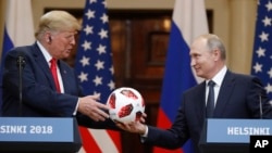 普京总统在美俄峰会后的联合记者会上把一个足球送给川普总统。(2018年7月16日)