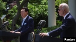 Presiden AS Joe Biden tampak mendengarkan Presiden Korea Selatan Yoon Suk Yeol berbicara dalam konferensi pers bersama di Gedung Putih, Washington, pada 26 April 2023. (Foto: Reuters/Leah Millis)