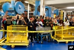 Employees of Carrier watch as President-elect Donald Trump and Vice President-elect Mike Pence take a tour in Indianapolis, Indiana, Dec. 1, 2016.