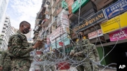 Tentara berjaga di luar gedung yang dikarantina (lockdown) di pusat kota Kuala Lumpur, Malaysia, 7 April 2020. (Foto: AP)