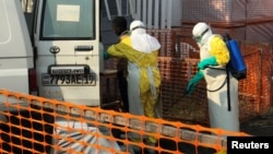 一名刚果(金)戈马市的医护人员在一辆救护车上喷洒消毒剂。(2019年7月18日)