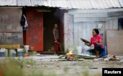 Para pekerja migran dari Indonesia di luar gubuk mereka di Kuala Lumpur, Malaysia, 19 Juni 2011. (Foto: Reuters)