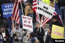 FILE - People gather to protest the United States' acceptance of Syrian refugees at the Washington State Capitol in Olympia, Wash., Nov. 20, 2015.