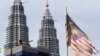 Bendera Malaysia yang sudah tampak robek terpasang di depan Menara Petronas di Kuala Lumpur, Malaysia, pada 10 April 2018. (Foto: AP/Vincent Thian)