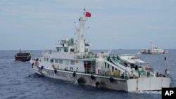 Sebuah kapal penjaga pantai China mencoba menghalangi jalan kapal pemasok Filipina, kiri, saat kapal tersebut menuju Scarborough Shoal, yang secara lokal dikenal sebagai Ayungin Shoal, di Laut China Selatan yang disengketakan (foto: dok). 