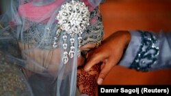 Winda Wahyuni mencium tangan suaminya Ahmad Yasir Saputra usai menikah di sebuah masjid di Banda Aceh, 9 Desember 2012. Survei menunjukkan separuh remaja Indonesia percaya laki-laki harus menjadi penentu akhir berbagai keputusan rumah tangga. (Foto: Reuters/Damir Sagolj)