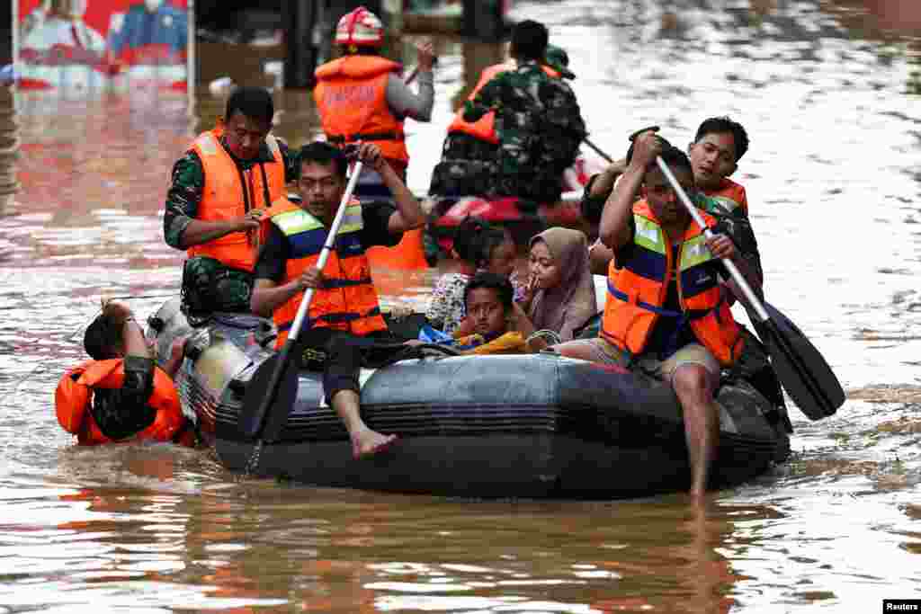 Rescuers evacuate people using a rubber boat from a flooded residential area following heavy rains in Jakarta, Indonesia. 