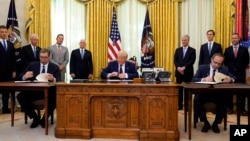 Predsednik Tramp na ceremoniji potpisivanja sporazuma o ekonomskim odnosima sa predsednikom Srbije Aleksandrom Vučićem i premijerom Kosova, Avdulahom Hotijem. (Foto: AP/Evan Vucci)