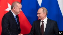 FILE - Russian President Vladimir Putin, right, and Turkish President Recep Tayyip Erdogan shake hands during a news conference after their talks in the Kremlin, in Moscow, March 5, 2020.