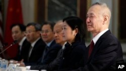 FILE - Chinese Vice Premier Liu He, right, sits next to a translator and members of the Chinese delegation as senior U.S. and Chinese officials resume trade negotiations, Feb. 21, 2019, in the Indian Treaty Room of the Eisenhower Executive Office...