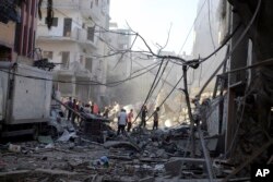 Warga Palestina memeriksa kerusakan rumah yang hancur akibat serangan udara Israel di kamp pengungsi Jabaliya, di pinggiran Kota Gaza, Minggu, 5 November 2023. (Foto: AP)